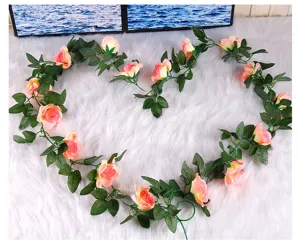Primo piano di vite di rose finte rosa, decorazione a cuore su sfondo bianco soffice.