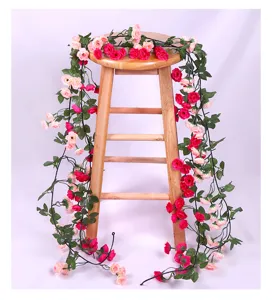Detailed close-up view of artificial pink and red rose flower vine garland for home decor.