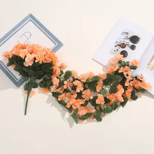 Vue détaillée de guirlandes de fleurs artificielles orange pour la décoration murale.
