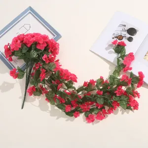 Vue détaillée de la vigne de fleurs suspendues roses artificielles avec feuilles vertes.