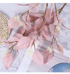 Détail de feuille d'eucalyptus artificielle, branche de feuillage rose pour décoration et art floral.