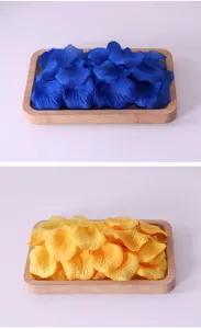 Detailansicht künstlicher blauer und gelber Rosenblüten in Holzschalen zur Dekoration.