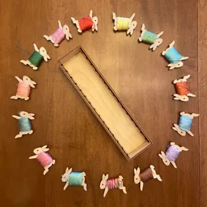 Creative wooden animal thread spool set with storage box for DIY sewing and craft projects.