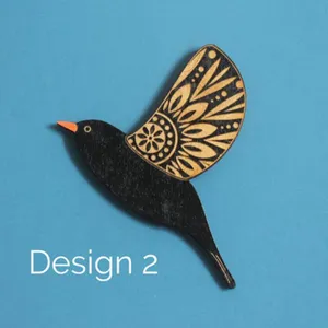 Detailed close-up view of a wooden bird wall hanging with intricate carved wing patterns.