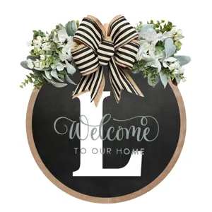 Corona rotonda rustica in legno per porta d'ingresso con eucalipto, fiocco e lettera di benvenuto.