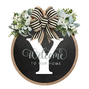 Targa da porta rotonda in legno con ghirlanda di fiori e fiocco per decorazione ingresso.
