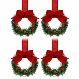 Detail shot of miniature Christmas wreaths with red bows berries and ribbon hanging loops.