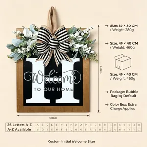 Targa benvenuto porta in legno con lettera personalizzata foglie di eucalipto e fiocco.