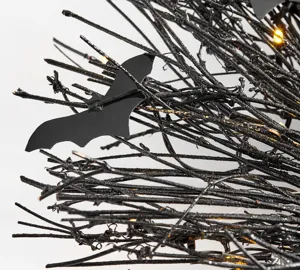 Dettaglio di ghirlanda di rami neri di Halloween con ornamento di pipistrello e LED.
