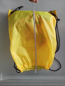 Yellow drawstring backpack detail view showing product height measurement, practical storage bag.