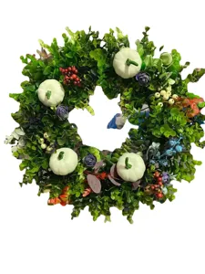 Halloween eucalyptus leaf wreath with white mini pumpkins and berries for front door decor.