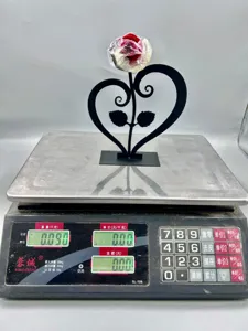 Detail shot of romantic metal heart rose ornament displayed on scale, perfect gift idea.