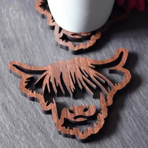 Highland cow wooden coaster detail, rustic hollow wood drink mat for home kitchen decor.