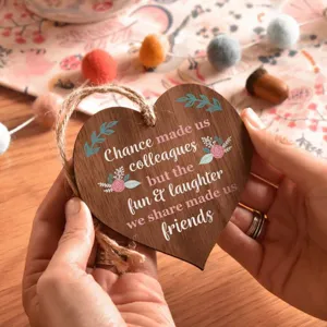 Close-up detail of a wooden heart plaque with friendly quote and hanging twine rope.