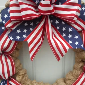 American flag burlap wreath door hanging, red white blue patriotic party decor detail.