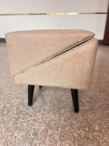 Close-up detail of the split pet stool featuring textured beige fabric and black wooden legs.