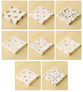Vue détaillée de lingettes de gaze en coton pour bébé avec motifs mignons et tissu doux.