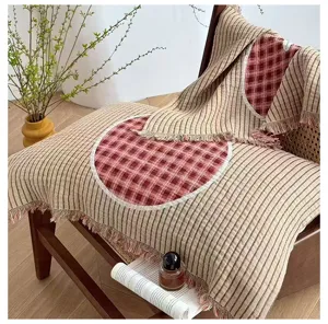 Detailed view of gauze pillow cover with plaid circle patch, fringe edge, and stripe pattern.