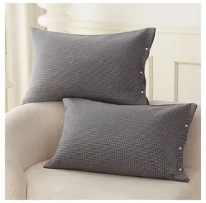 High density pure cotton gauze pillowcase detail showing minimalist snap button design and classic plaid.