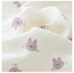 Détail de tissu en gaze douce avec joli imprimé lapin violet, texture délicate bébé.