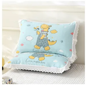 Detail view of soft cotton gauze children pillowcase with white lace trim and cute dino print.