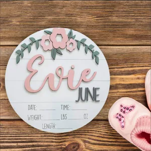 Detalle de cartel de anuncio de nacimiento de madera para recién nacido con nombre Evie y flores.