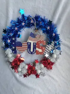 Detailed view of the American Independence Day wreath with blue tinsel and patriotic wooden sign.