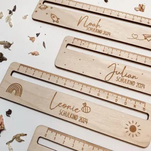 Vista dettagliata di righelli scolastici in legno con incisioni personalizzate e scale di misura.
