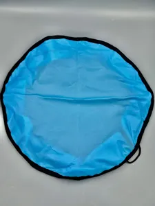 Round blue toy storage bag detail, waterproof fabric with black drawstring edge, portable use.