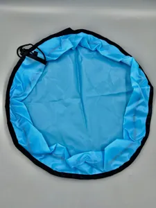 Detailed close-up of blue circular toy storage bag with black trim and drawstring design.