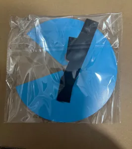 Accessorio fotografico circolare blu con ritaglio e cinturino in sacchetto trasparente.