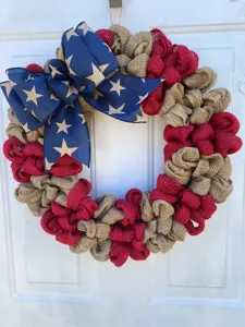 American Independence Day burlap wreath with patriotic blue star bow for front door decor.