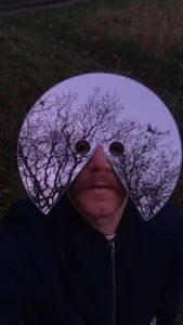 Dettaglio della maschera facciale a specchio creativa con superficie riflettente per foto all'aperto.