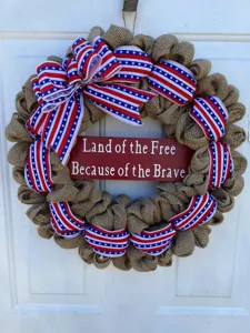 Detail view of the patriotic burlap wreath with star ribbons and wooden sign for decoration.