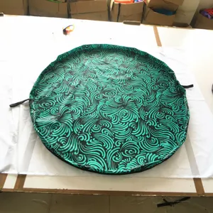 Detailed view of the waterproof toy storage bag with green swirl pattern and drawstring.