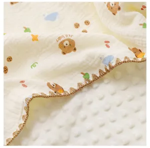 Gros plan détaillé de la couverture bébé en gaze avec un joli motif d'ours et dos minky.