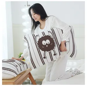 Close-up detail of soft cotton gauze pillowcase featuring cute cartoon design and neat stripes.