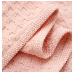Close-up detail of pink waffle weave fabric pillow towel, soft and breathable textile texture.