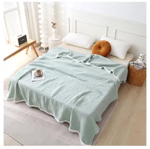 Vue détaillée d'une couverture en gaze de coton quadruple vert sauge dans une chambre cosy.