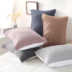 Close-up detail of Japanese style cotton gauze pillow towels in cozy bedroom bedding scene.