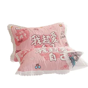 Cute pink quilted pillow cover with lace trim and embroidery for cozy home decor.
