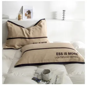 Cotton gauze pillowcase detail view featuring minimalist typography and contrast piping design.
