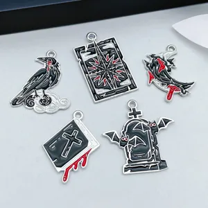 Close-up of gothic Halloween enamel charms including a raven, tombstone, and book.