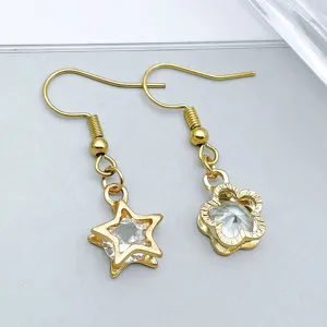 Dettaglio ravvicinato di ciondoli a stella e fiore in oro KC con pietre in zircone trasparente