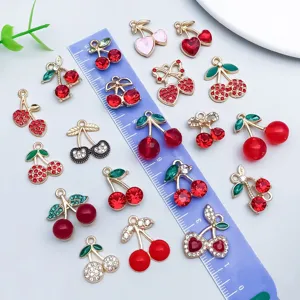 Nahaufnahme verschiedener Kirsch-Anhänger aus Emaille und Strass für DIY-Schmuck