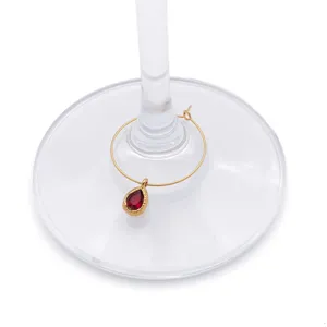 Dettaglio ravvicinato di un ciondolo dorato con una pietra preziosa rossa a forma di goccia