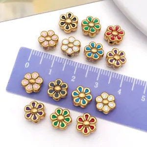 Detalle de cuentas de margaritas de esmalte con regla para mostrar el tamaño de 8mm.