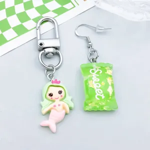 Nahaufnahme von süßen grünen Meerjungfrauen- und Bonbon-Resin-Anhängern für DIY-Schmuck