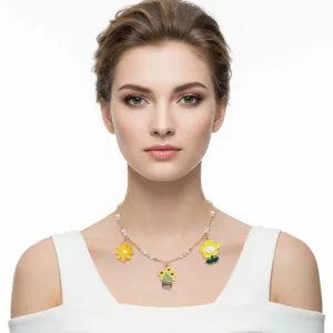 Detail view of yellow sunflower and daisy enamel charms on a gold-plated necklace