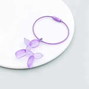 Detailed view of a purple translucent balloon dog pendant with a matching wire keyring